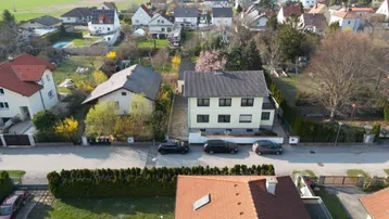 Luftaufnahme eines Wohnhauses in einer ländlichen Umgebung mit angrenzenden Feldern und weiteren Häusern.