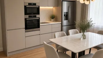 Moderne Küche mit integrierten Geräten, heller Arbeitsplatte und Essbereich mit stilvoller Beleuchtung.