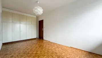 Helles Zimmer mit Parkettboden und praktischen Einbauschränken, ideal als Schlafzimmer oder Büro.