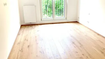 Helles Schlafzimmer mit Parkettboden und französischem Balkon, bereit zum Einzug.