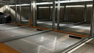 Modernes, mehrstöckiges Parksystem in einer Tiefgarage mit automatisierten Stellplätzen für Fahrzeuge.