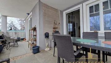 Große überdachte Terrasse mit Outdoor-Möbeln und Blick ins Grüne, ideal zum Entspannen.