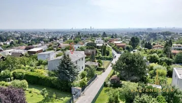 Luftaufnahme eines Wohngebiets mit Blick auf die Stadt und ein markiertes Haus.