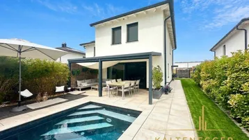 Modernes Einfamilienhaus mit privatem Pool, überdachter Terrasse und gepflegtem Gartenbereich.