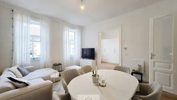 Heller Wohn- und Essbereich mit modernem Sofa, Esstisch und Holzboden, ideal für geselliges Beisammensein.
