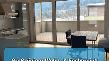 Großzügiger Wohn- und Essbereich mit offener Küche, großen Fenstern und Zugang zum Balkon.