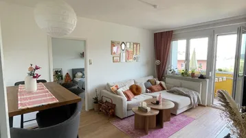 Heller offener Wohnbereich mit Holzboden, gemütlichem Sofa und integriertem Barbereich.
