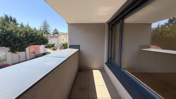 Heller Balkon mit Fliesenboden und Blick ins Grüne, ideal für entspannte Stunden im Freien.
