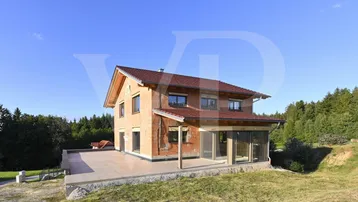 Große, gepflasterte Terrasse am Rohbau mit weitem Blick ins Grüne.