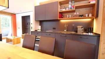 Moderne Küchenzeile mit dunklen Schränken, Granitarbeitsplatte und integrierten Geräten.