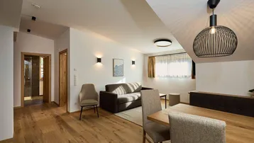 Heller Wohn- und Essbereich mit Holzboden, bequemer Couch und modernem Esstisch.