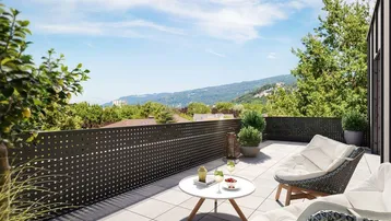 Moderne möblierte Terrasse mit Bergblick und grüner Umgebung unter blauem Himmel.