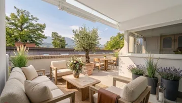 Geräumige Terrasse mit bequemen Loungemöbeln, Esstisch und Blick ins Grüne.