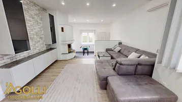 Großzügiges Wohnzimmer mit hellem Laminatboden, Kamin und gemütlicher Sitzecke.