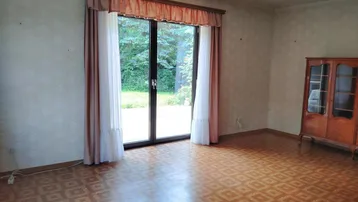 Geräumiges Zimmer mit direktem Zugang zum Garten und gemustertem Bodenbelag.