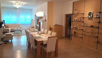 Geräumiger offener Wohn- und Essbereich mit hellem Holzboden und modernem Esstisch.