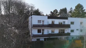 Mehrfamilienhaus mit mehreren Balkonen und moderner Fassadengestaltung.