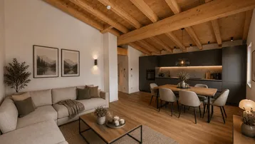 Helles Wohn- und Esszimmer mit Holzbalkendecke, modernem Sofa und integrierter Küche.