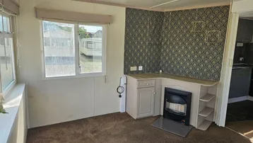 Gemütliches Wohnzimmer mit Teppichboden, dekorativer Tapete und einem Kamin.