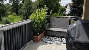 Geräumiger Balkon mit Grillbereich, Sitzgelegenheiten und Blick ins Grüne.