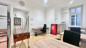 Helles Büro mit mehreren Arbeitsplätzen, Parkettboden und großen Fenstern, ideal für eine moderne Arbeitsumgebung.
