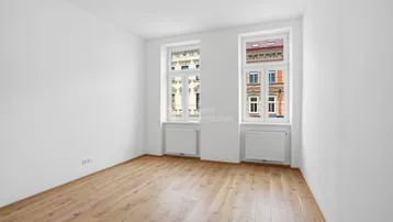 Helles Zimmer mit neuem Parkettboden und Blick auf die gegenüberliegenden Gebäude.