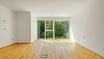 Helles, unmöbliertes Wohnzimmer mit großen Fenstern und Parkettboden, bietet viel natürliches Licht.