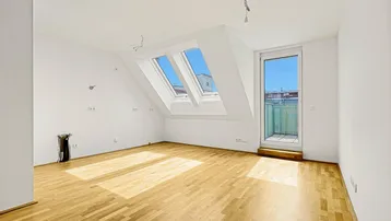 Lichtdurchfluteter Dachgeschossraum mit Holzboden, Dachfenstern und Zugang zu einem Balkon.