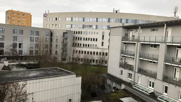 Weitläufiger Blick auf die umliegende Wohnbebauung und Grünflächen unter bewölktem Himmel.