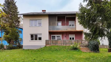 Ansicht des Hauses von der Gartenseite mit Balkonen und Terrasse im Erdgeschoss.