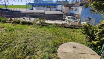 Grüner Gartenbereich mit einer Betonabdeckung und Blick auf die Umgebung.