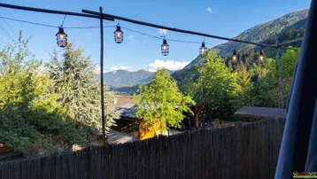 Panoramablick vom Balkon auf die umliegende Berglandschaft und Bäume.