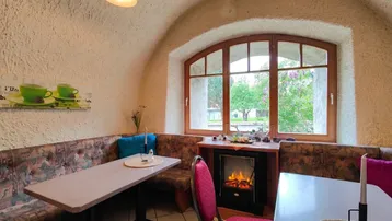 Gemütliche Sitzecke mit gewölbter Decke, großem Fenster und dekorativem Kamin.