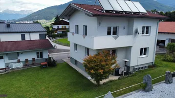 Freistehendes Einfamilienhaus mit Solaranlage, gepflegtem Garten und Bergblick in ländlicher Umgebung.