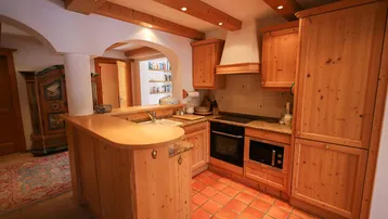 Rustikale Holzküche mit Granitarbeitsplatte, Frühstücksbar und integrierten Geräten.
