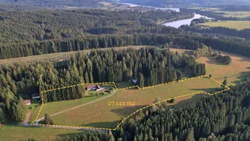 Luftaufnahme des Anwesens mit weitläufigen Feldern, Wald und einem Fluss in der Ferne.