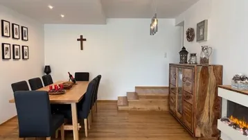 Heller Essbereich mit Holztisch, modernen Stühlen und einem dekorativen Sideboard aus Massivholz.