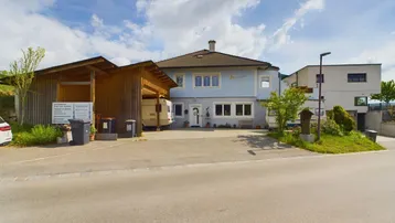 Ansicht des Hauses von der Straße mit Carport und ländlicher Umgebung.
