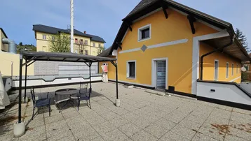 Große, geflieste Terrasse mit Pergola und Gartenmöbeln, ideal für entspannte Stunden im Freien.