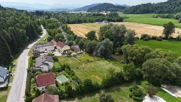 Luftaufnahme eines Grundstücks mit umliegender Natur, Feldern und einem Fluss im Hintergrund.