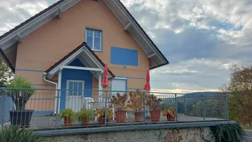 Großzügige Terrasse mit Metallgeländer und Blick auf die umliegende Landschaft, ideal für Entspannung im Freien.
