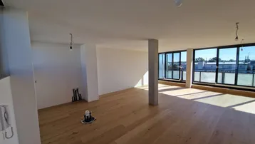 Geräumiger, heller Wohnbereich mit großen Fenstern und neuem Parkettboden, bereit für die Gestaltung.