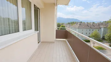 Heller Balkon mit Fliesenboden und weitem Blick auf die Berge und die Umgebung.