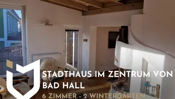 Helles Wohnzimmer mit Holzbalkendecke, Kamin und gemütlicher Einrichtung, inklusive Werbebanner.