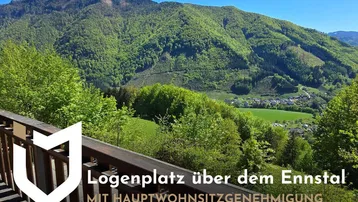 Panoramablick vom Balkon auf die grüne Berglandschaft und das malerische Ennstal unter strahlend blauem Himmel.