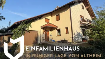 Einfamilienhaus in ruhiger Lage von Altheim mit Garage und Balkon unter blauem Himmel.