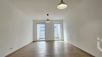 Heller Wohnraum mit Holzboden und zwei französischen Balkonen für viel Licht.