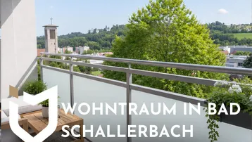 Möblierter Balkon mit Blick auf die Stadt und die umliegende grüne Landschaft.