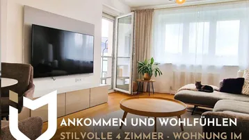 Modernes Wohnzimmer mit Holzboden, großem Fernseher und Zugang zu einer Loggia mit Grünblick.