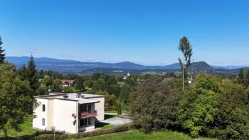 Weitläufiger Blick auf das Gebäude und die umliegende Landschaft mit Bergen im Hintergrund.